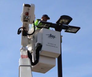 Image of a parking lot light with a Bay Lighting bucket truck technician on Bay Lighting's website