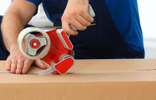 Image of a person taping up a box on Bay Lighting's website
