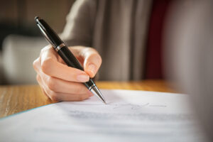 Image of a person signing a contract on Bay Lighting's Maryland commercial lighting website